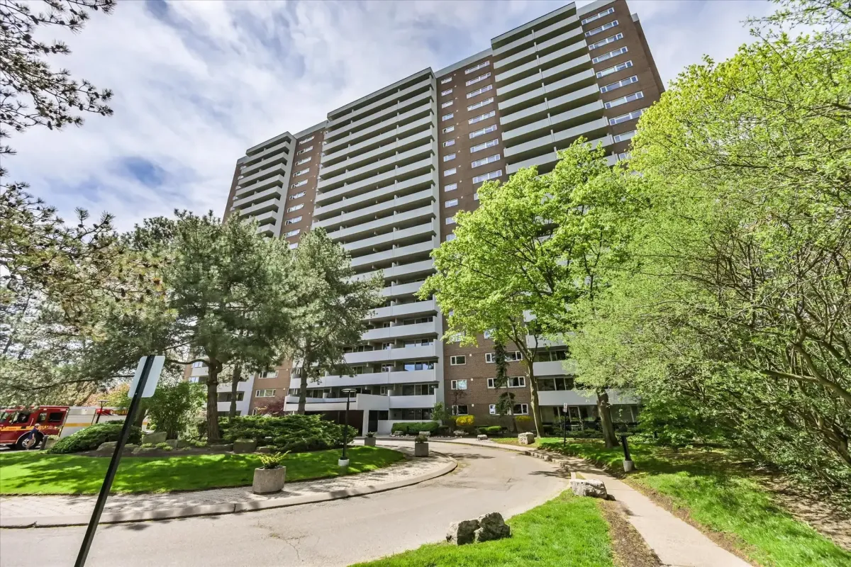 Angular street-level view of the 240 Scarlett Rd #912 condominium building with manicured lawns and green trees.
