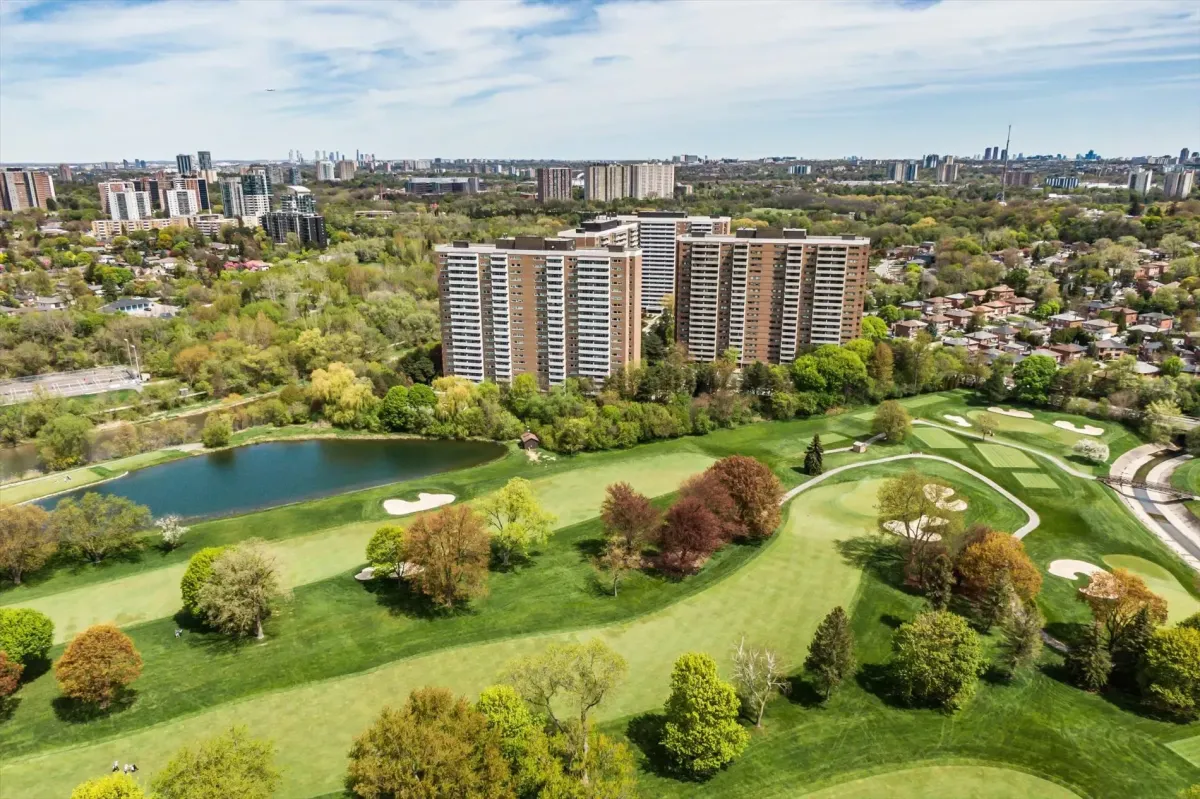 Scenic drone shot of 240 Scarlett Rd #912 surrounded by lush golf course greenery and a small lake.