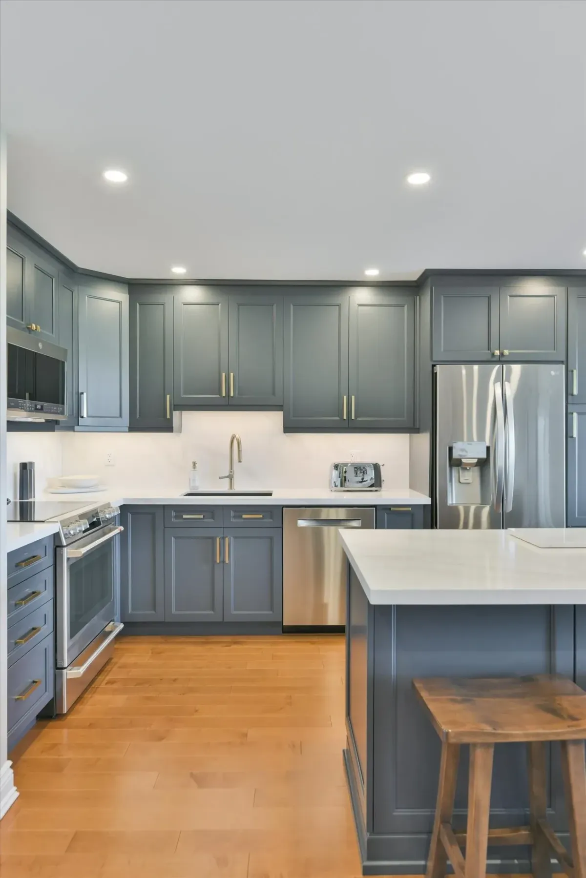 Seamless crown molding and integrated ceiling pot lights over grey kitchen cabinets in 240 Scarlett Rd #912.