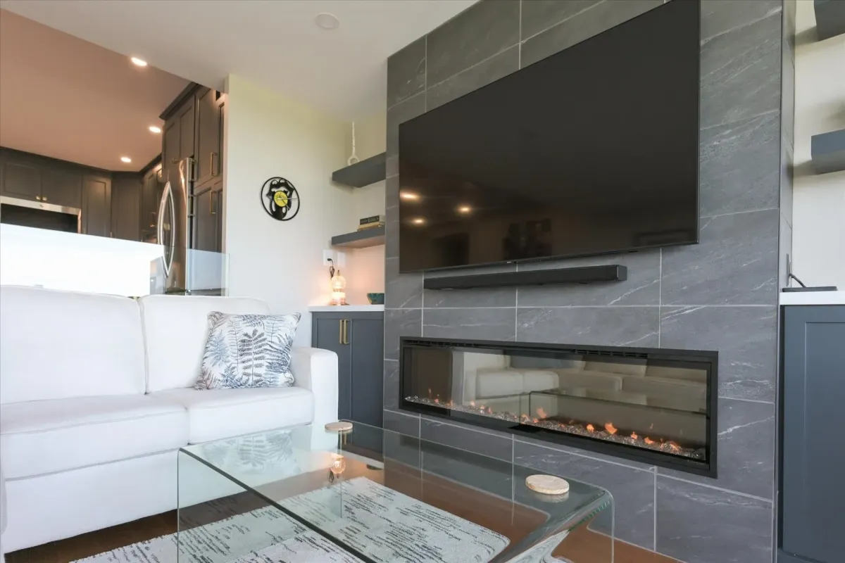Sleek contemporary linear electric fireplace built into a stone feature wall at 240 Scarlett Rd #912.