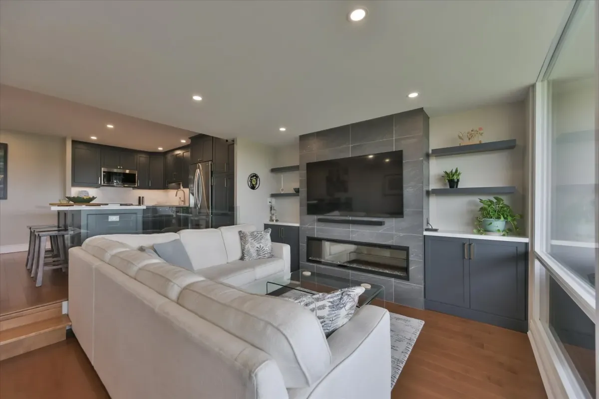Modern built-in entertainment unit and stone-look fireplace surround inside the living area of 240 Scarlett Rd #912.
