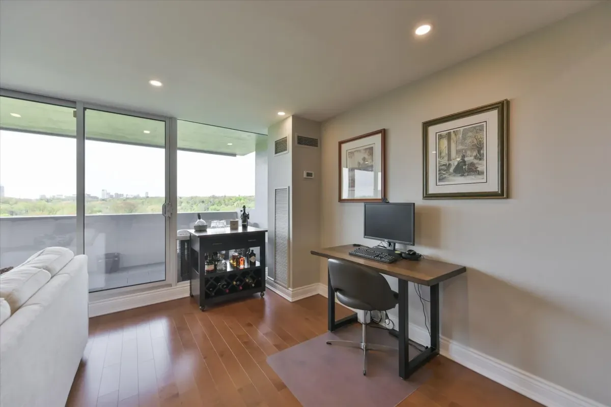 Dedicated home office workspace desk set up next to a bright window in the living area of 240 Scarlett Rd #912.