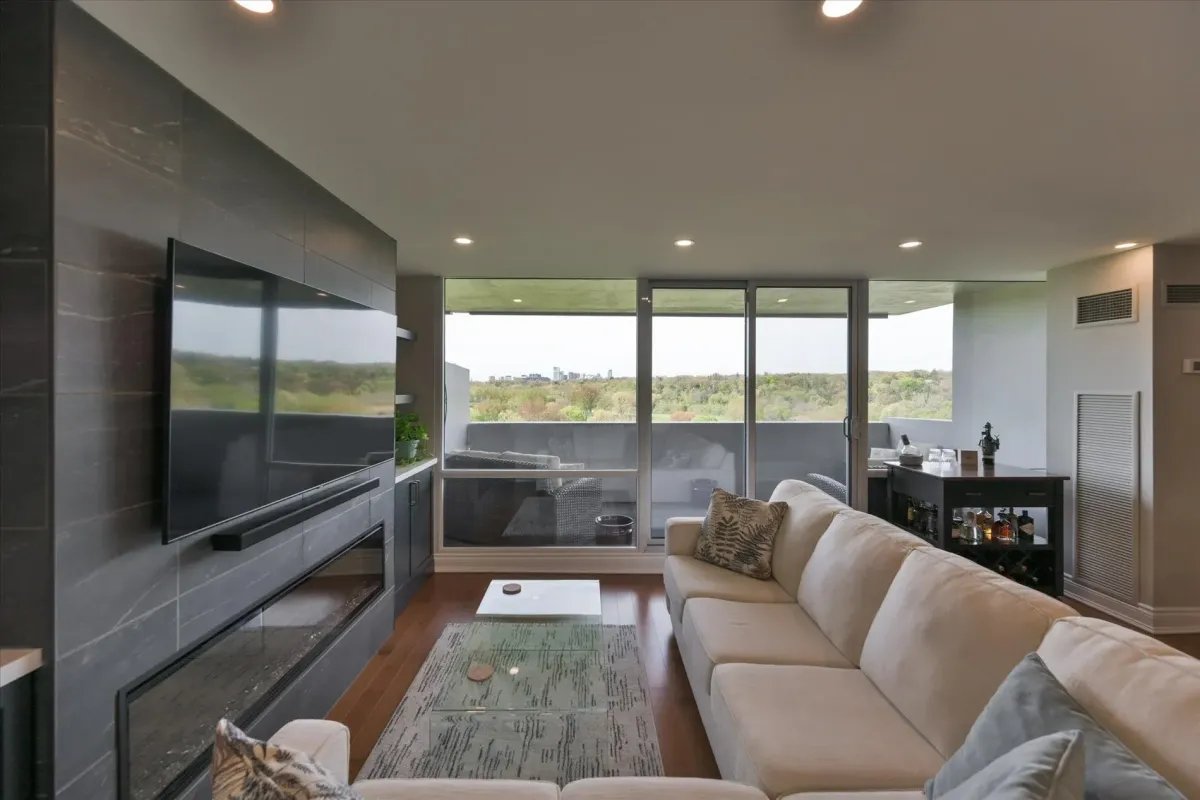 Sun-drenched living room at 240 Scarlett Rd #912 showcasing a large sectional sofa and panoramic window views.