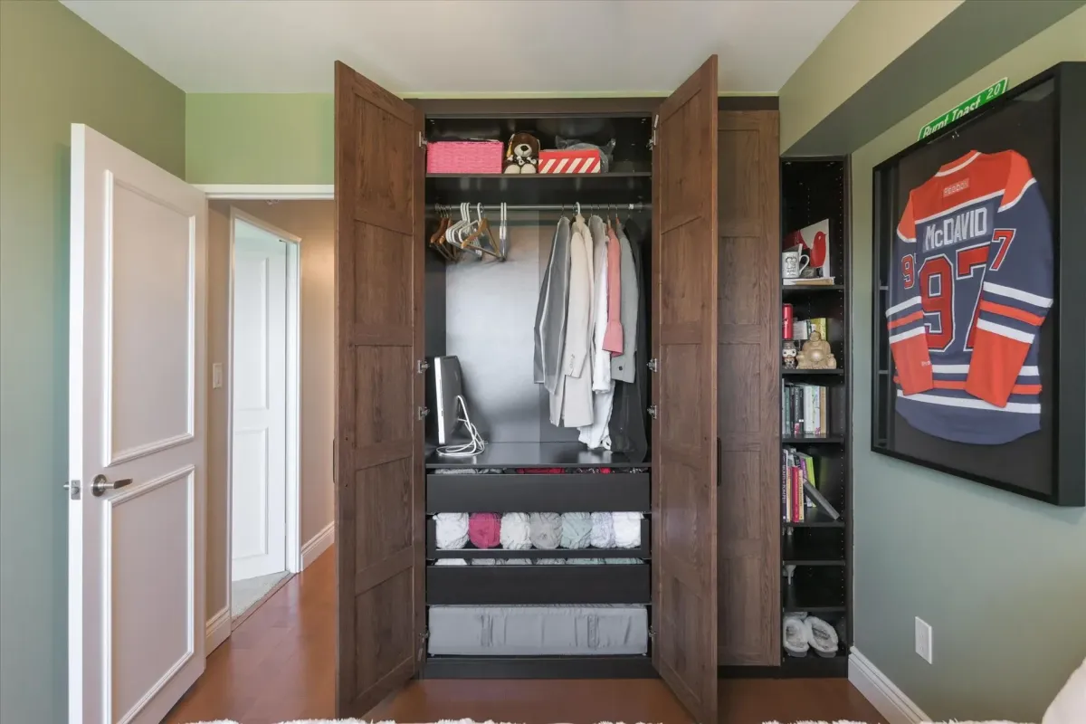 Opened custom wood wardrobe showing built-in drawers, cubbies, and shelving organization inside 240 Scarlett Rd #912.