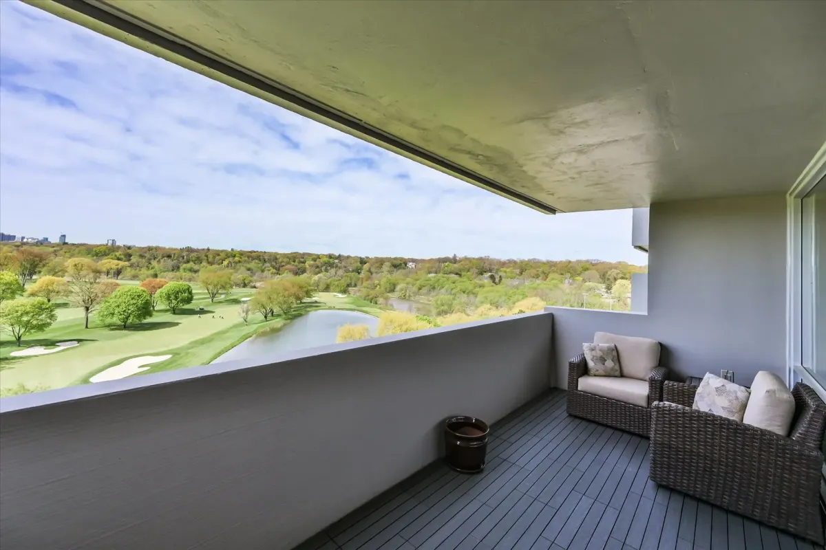 Spacious covered private balcony at 240 Scarlett Rd #912 overlooking green trees and a golf course.