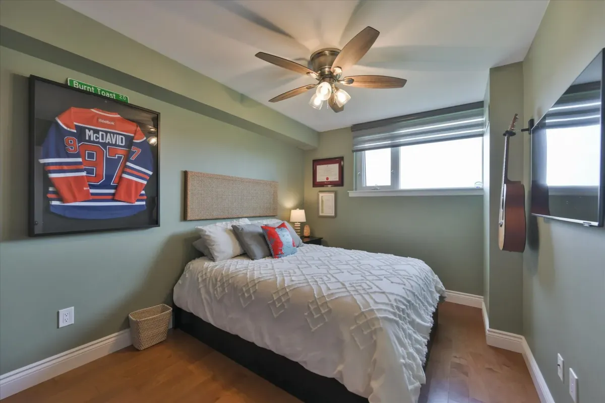Bright second bedroom inside 240 Scarlett Rd #912 featuring a large window, ceiling fan, and light green accent walls.