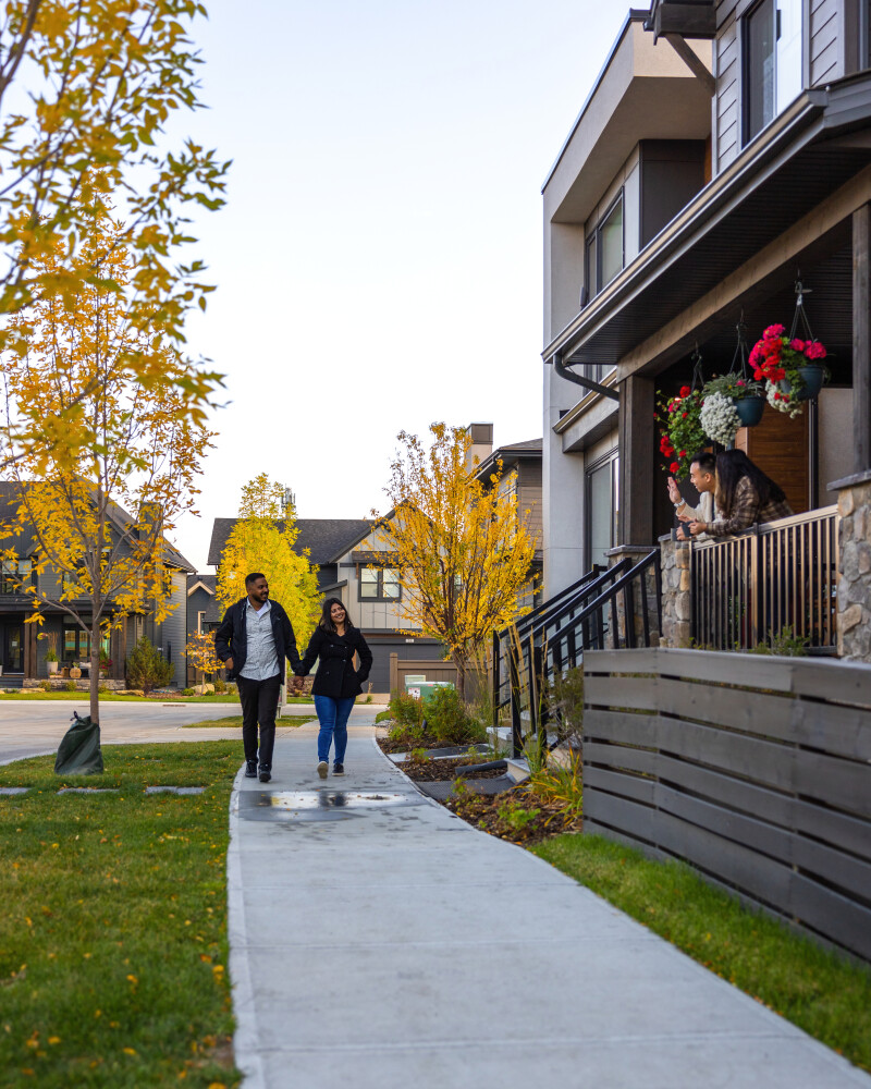 15020 Bow Trail SW Alpine Park Calgary family walking down pedestrian first porch front residential neighborhood street