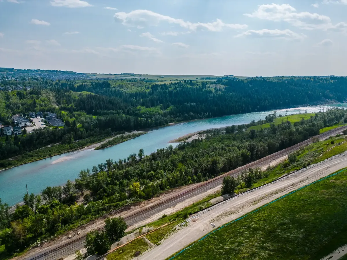 Rockland Park NW Calgary scenic aerial overview of the Bow River valley, green forests, and adjacent train tracks.