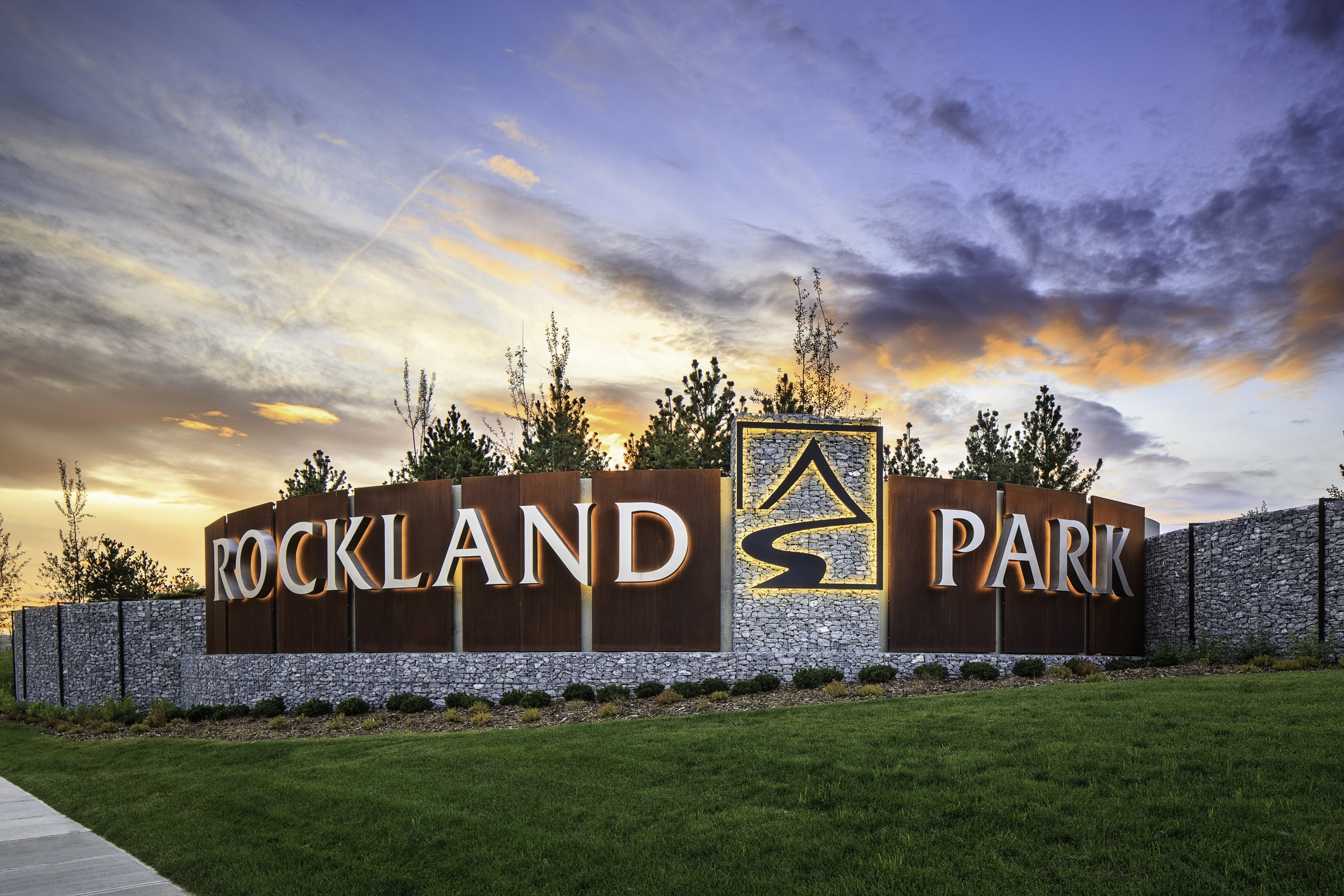 Rockland Park NW Calgary stone and metal community entrance monument sign at sunset.