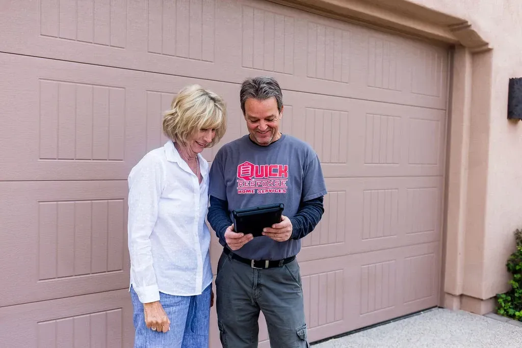 Smiling homeowner on the phone contacting a garage flooring company to request a free estimate.