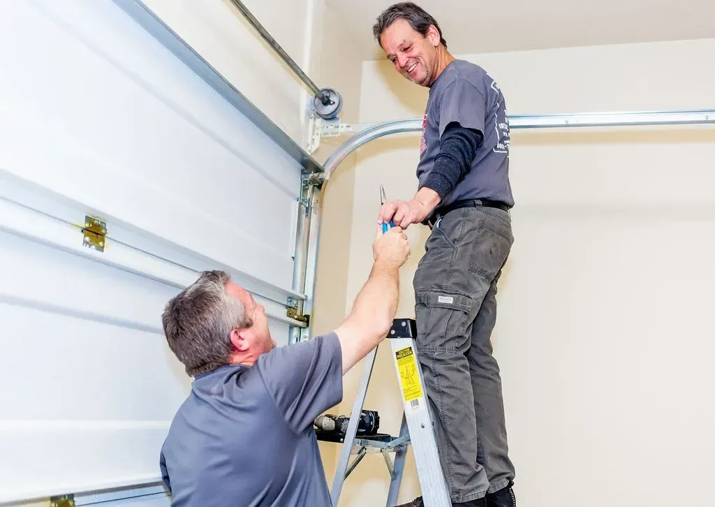 Professional installer applying epoxy floor coating along the edge of a concrete surface during the installation process.