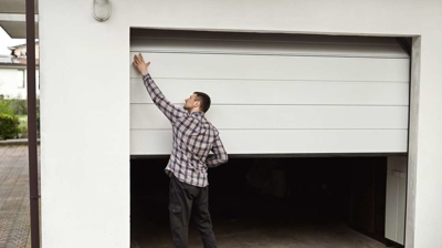 Man trying to close a stuck garage door