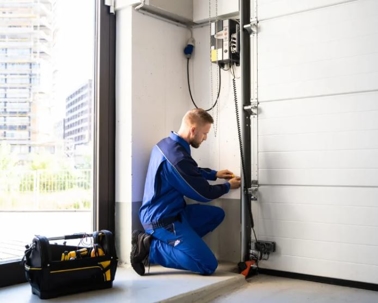 alt="man fixes garage door"