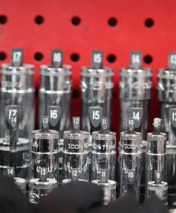 Close-up of a socket set and garage door repair tools organized on a red tool rack.