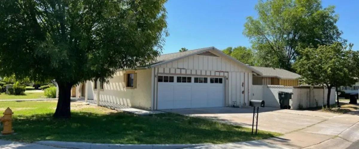 Suburban single-story home with attached garage, driveway, and front yard landscaping.