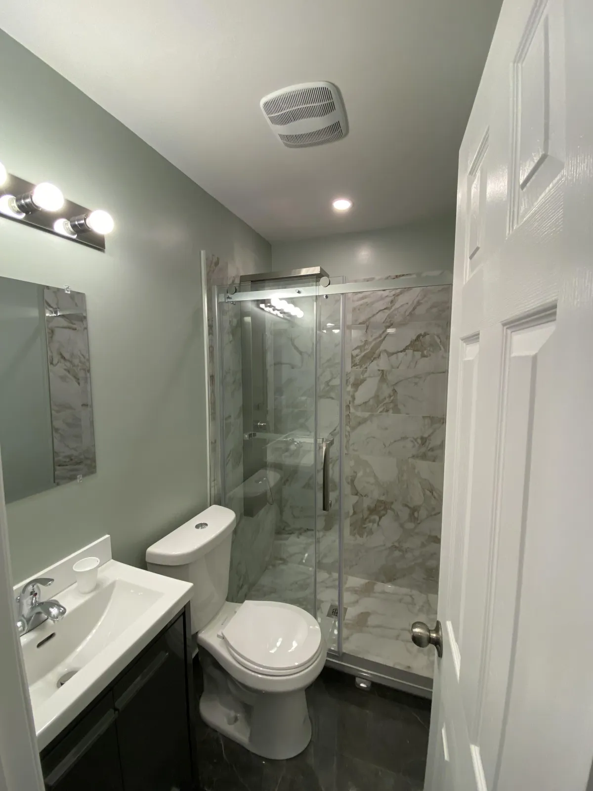 Luxurious bathroom renovation in Toronto featuring a spa-like walk-in shower and marble tiles.