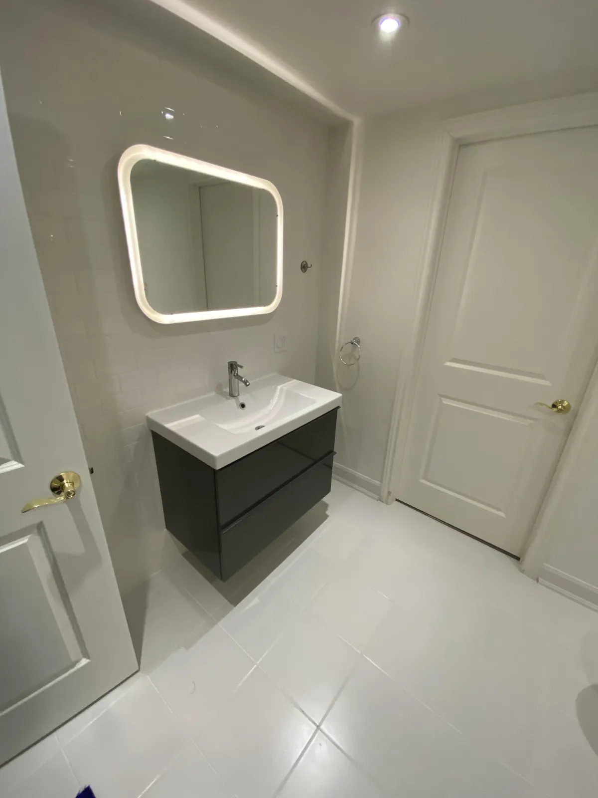 Small bathroom remodel in a Toronto condo with space-saving fixtures and bright lighting.