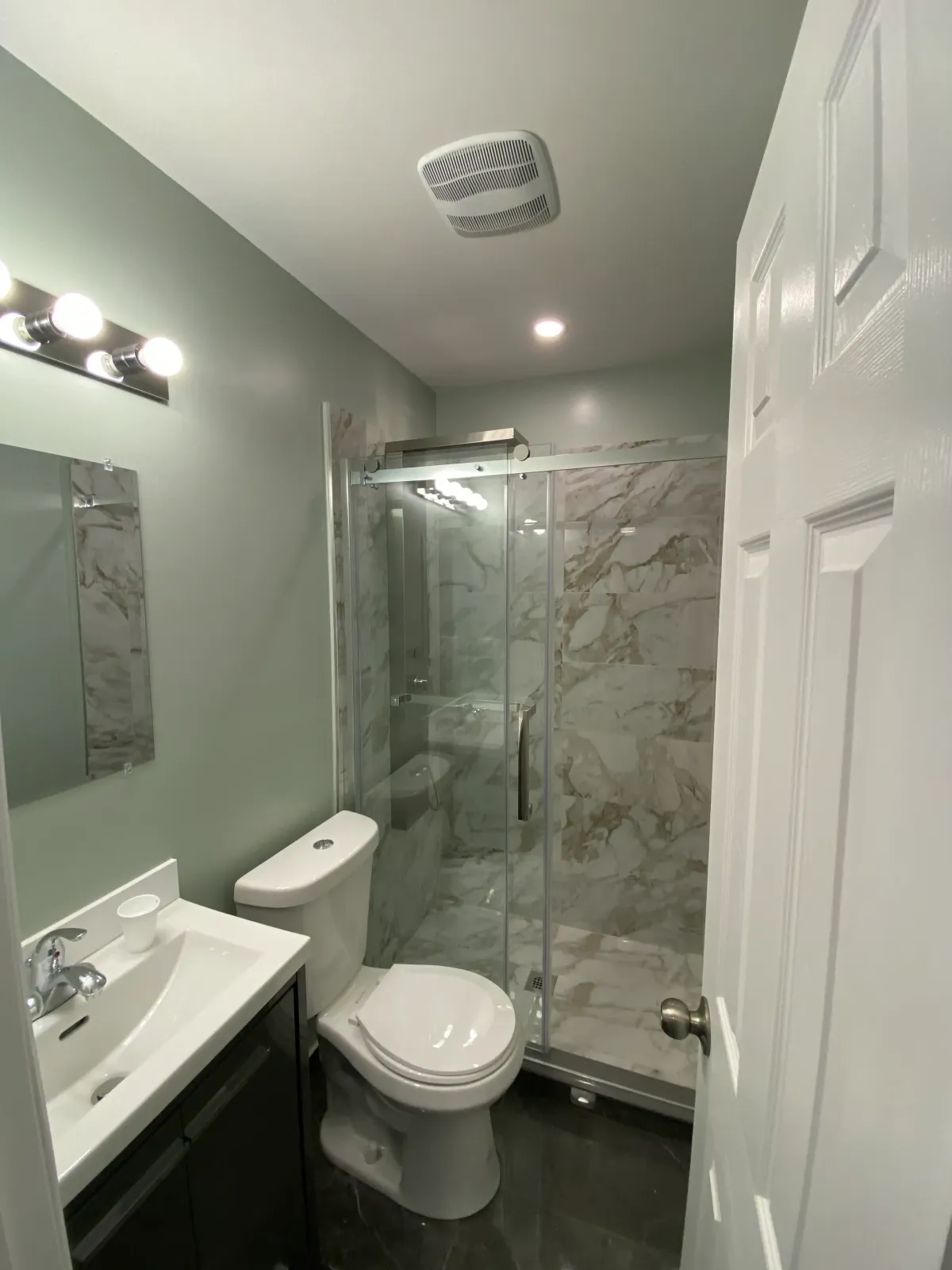 Luxurious bathroom renovation in Toronto featuring a spa-like walk-in shower and marble tiles.