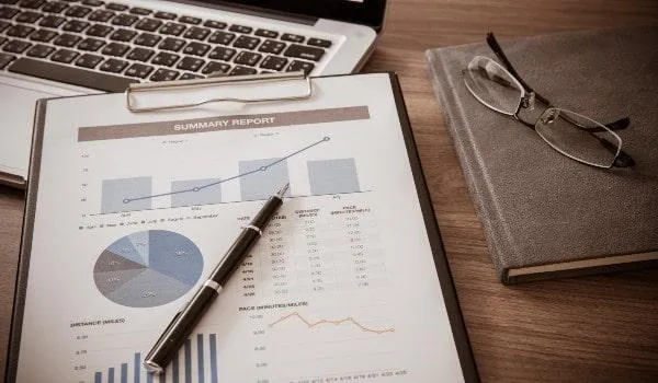 Financial report on a clipboard being reviewed with a pen