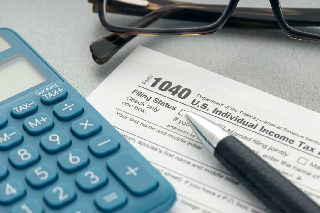 US 1040 tax form with calculator and pen