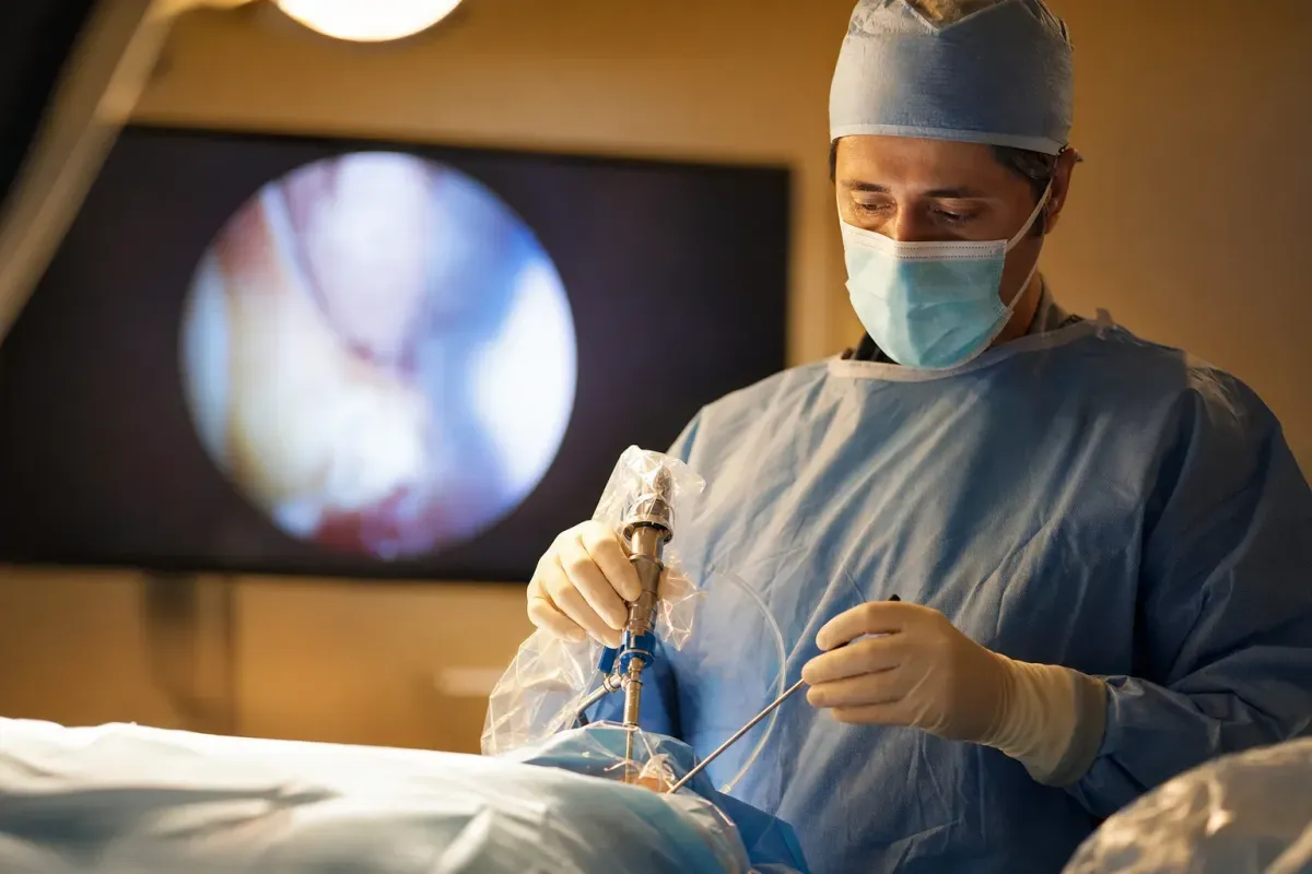 Surgeon using an endoscopic decompression instrument with a video screen in a warm operating room