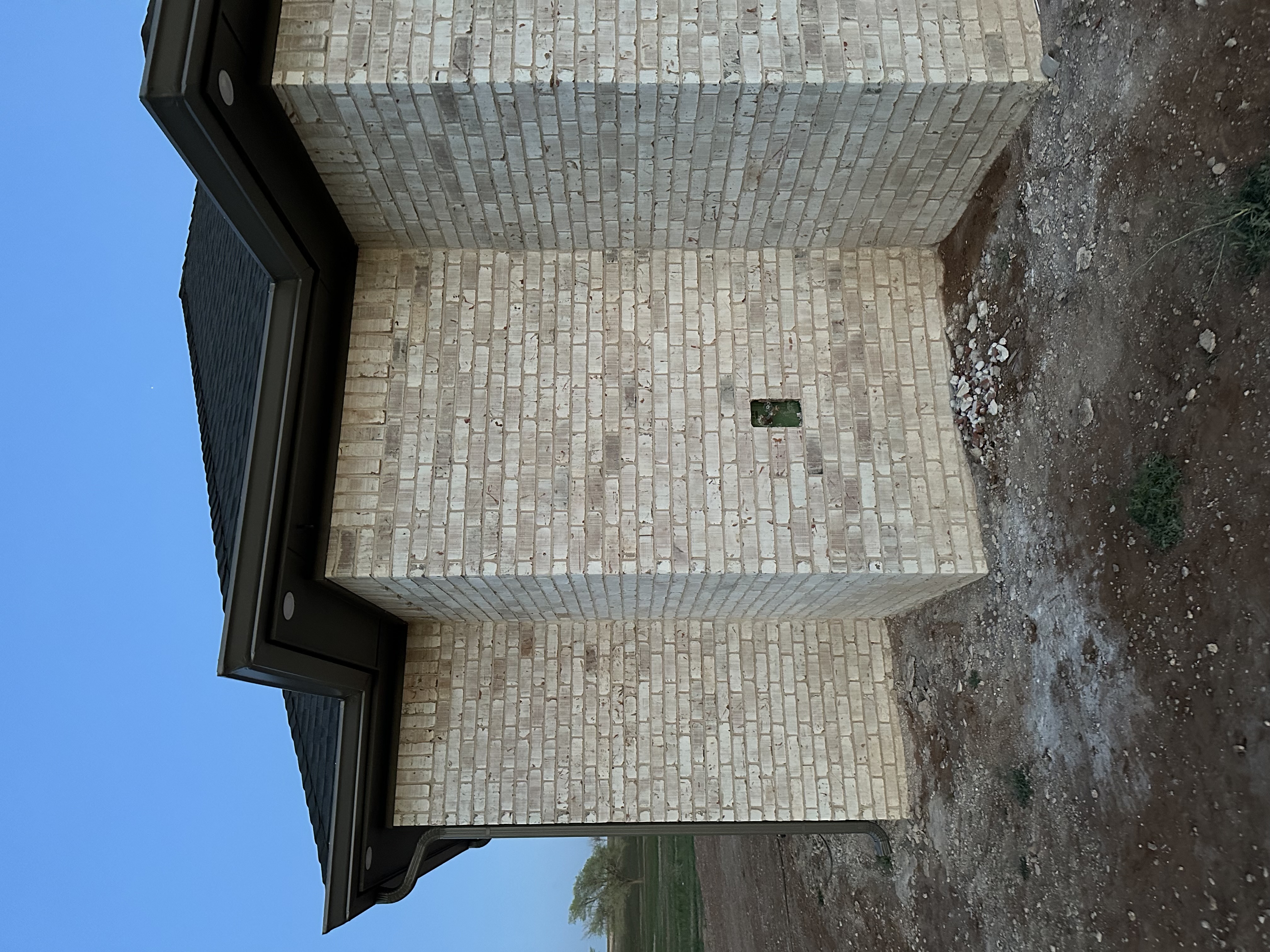 Technician installing seamless aluminum gutters at a residential home in Lubbock, Texas