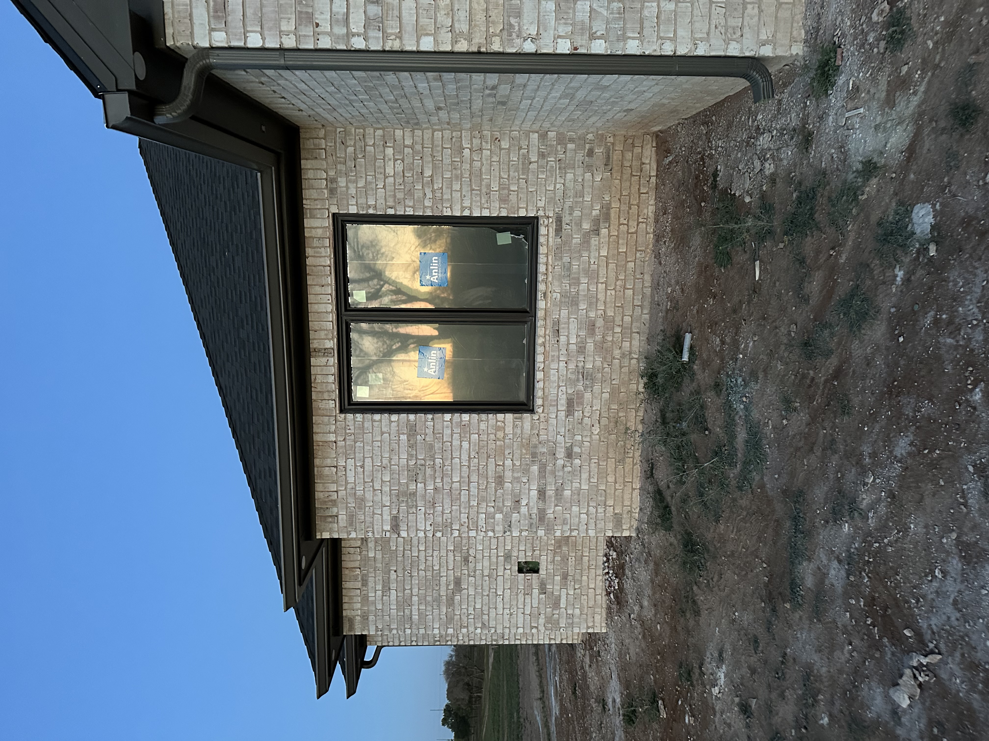 Technician installing seamless aluminum gutters at a residential home in Lubbock, Texas