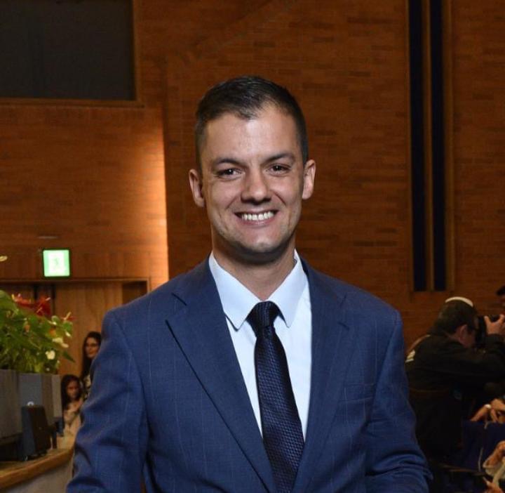 Worried mid-40s investor at a kitchen table scanning spreadsheets and loan offers.