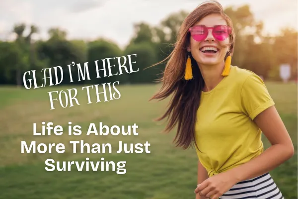Young woman in an open field smiling with the caption "Glad I'm Here For This - Life is About More Than Just Surviving"