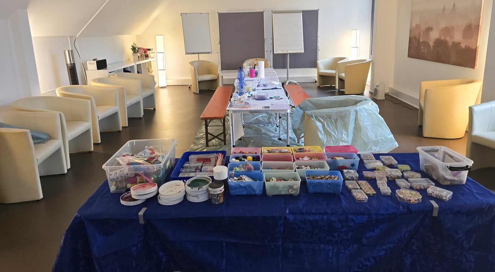 A bright room with a long table full of materials for creating