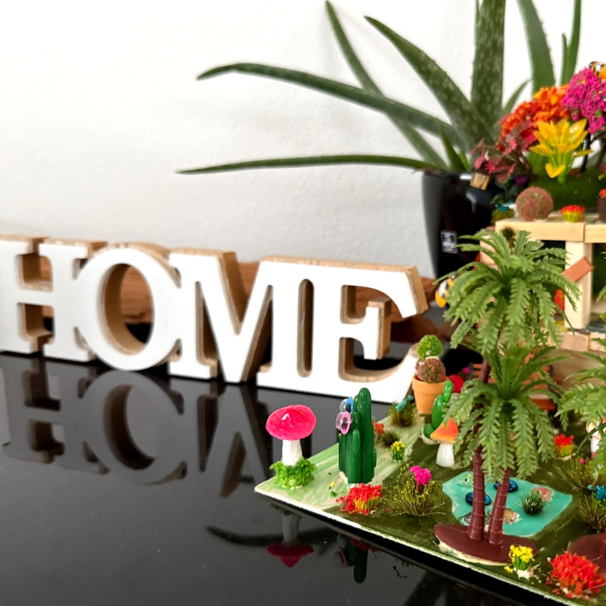 A little world with palm trees, a toadstool and the word HOME