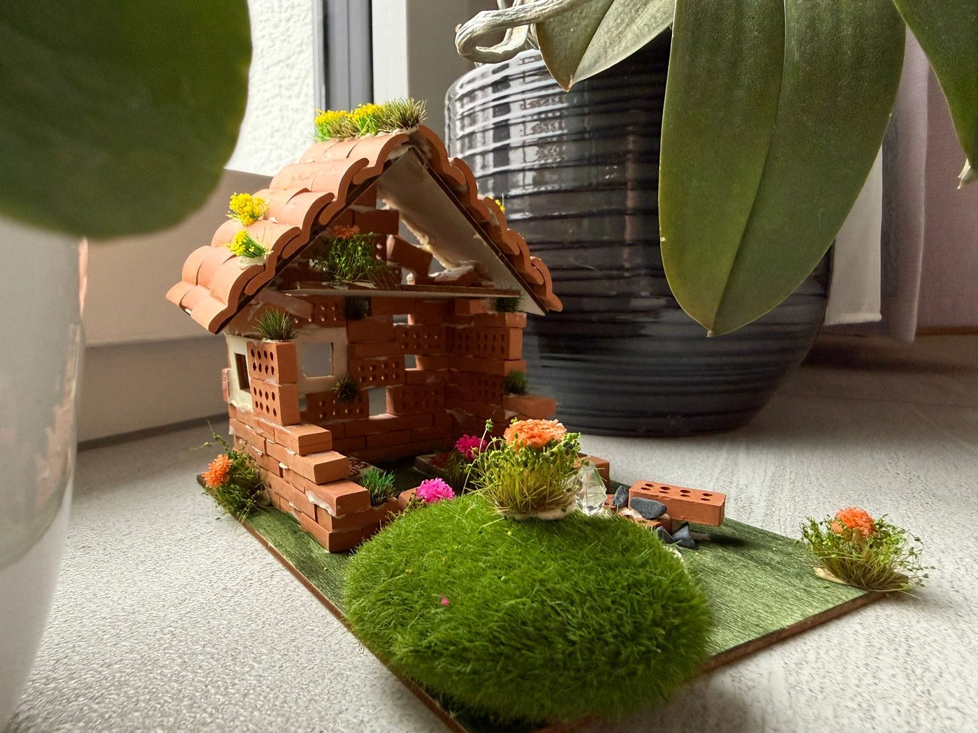 A handmade dream house of little bricks with a moss garden