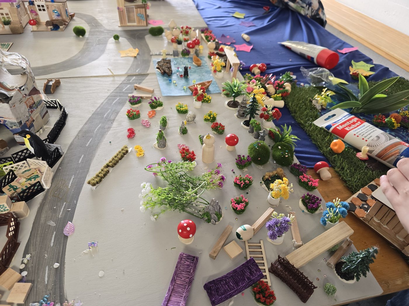 Nahaufnahme einer kleinen Stadt aus Holz mit Blumen, Wegen und Bäumen