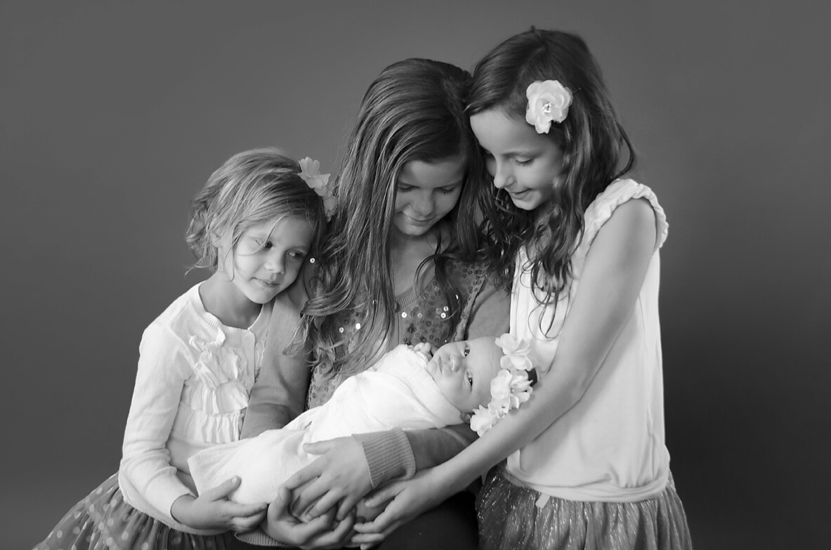 Newborn in Boise Idaho with sisters snuggling