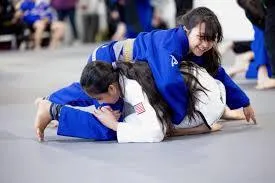 a shirtless man standing in front of a tree
