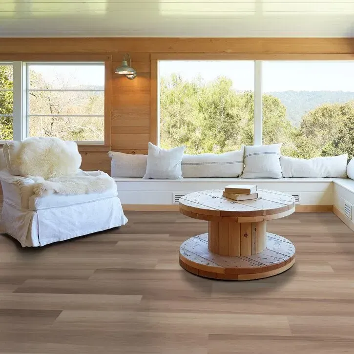 Bright living space featuring wide plank vinyl flooring and natural wood accents