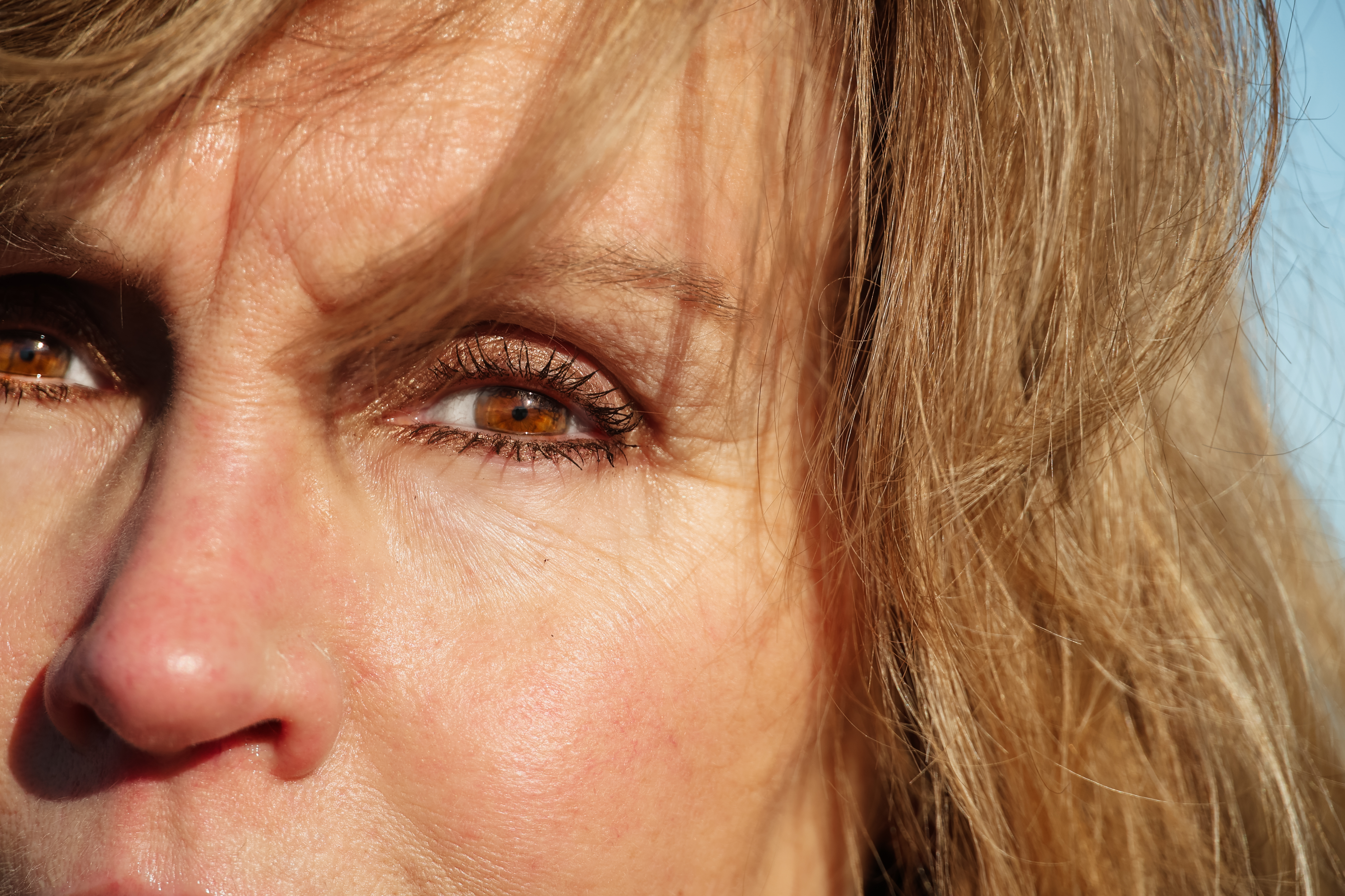 Focused woman with curly hair standing out in a bustling crowd, captured in motion