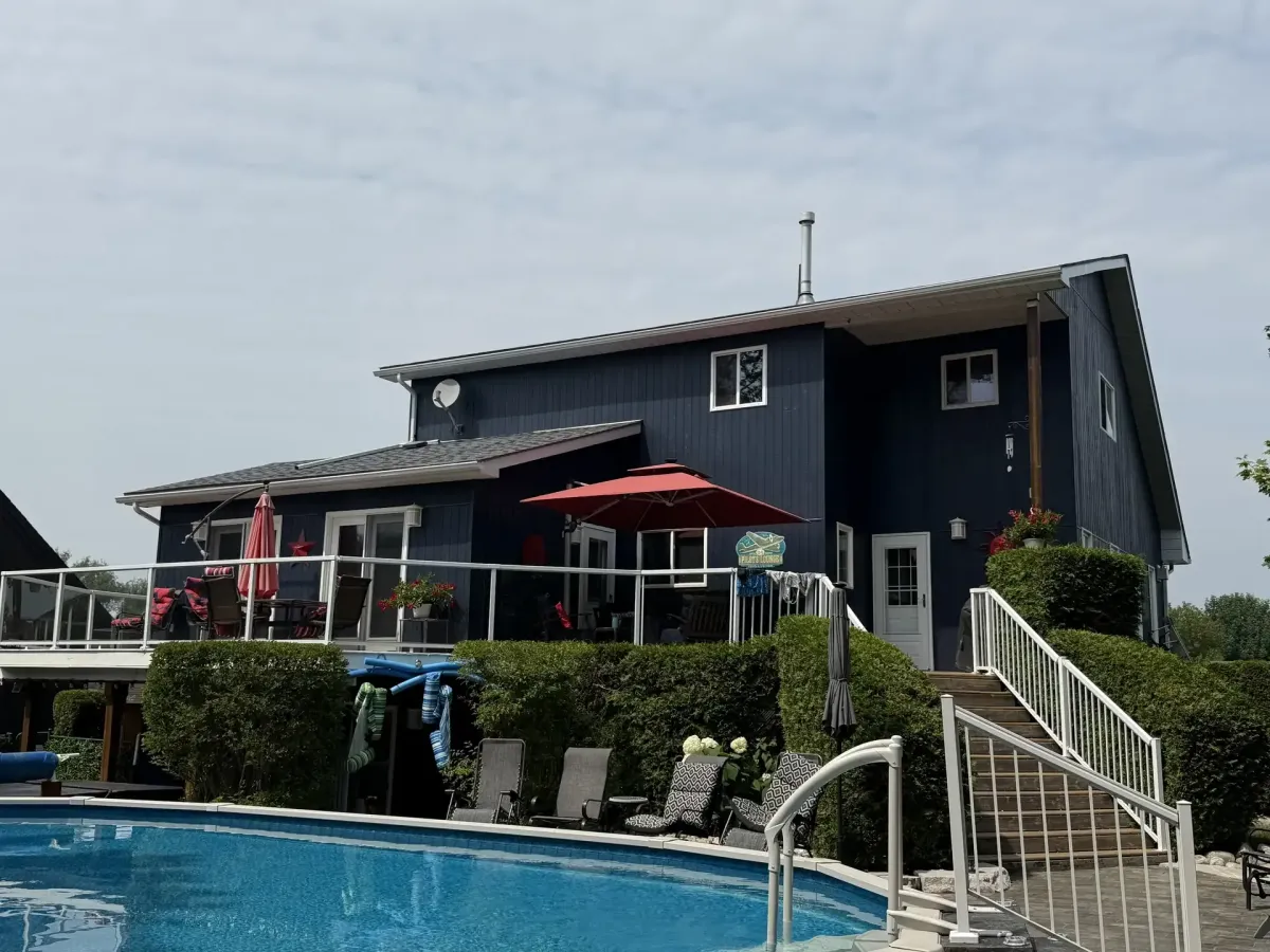Navy board and batten home with pool painted by Turtle Painting