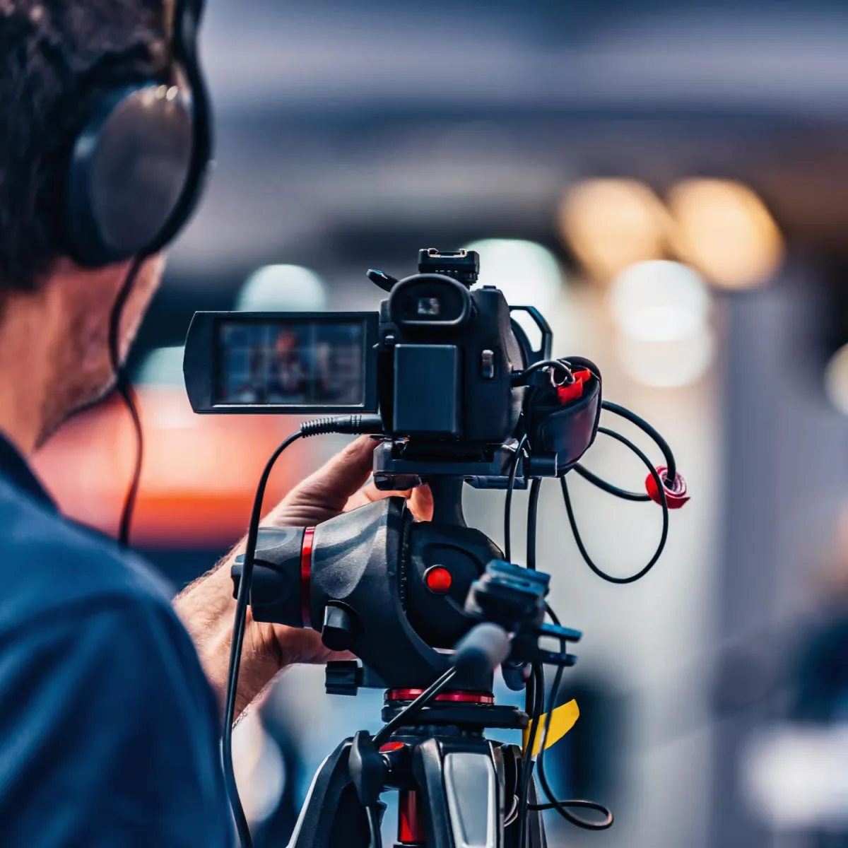 man filming with a camera and tripod