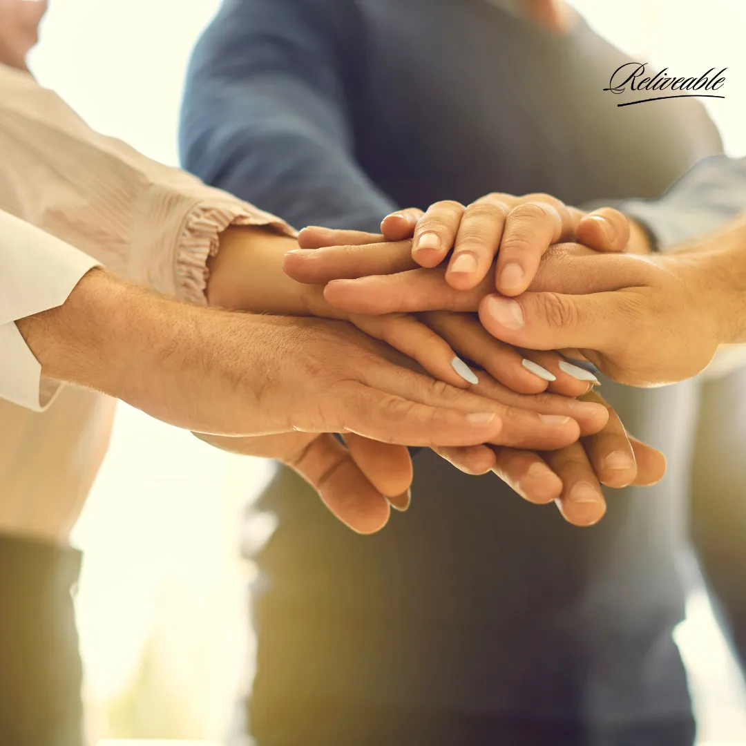 a group of staff members from ReLiveable.al handshaking in agreeance