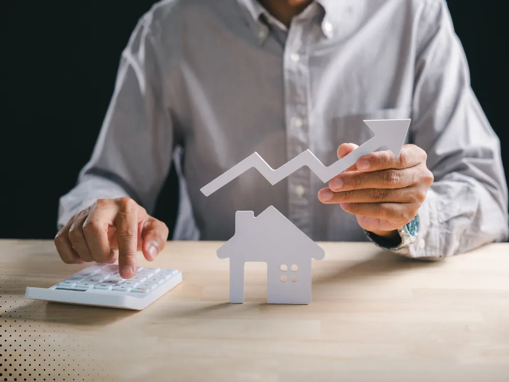 Real estate professional analyzing market trends with a home model and growth chart, symbolizing investment and property value analysis