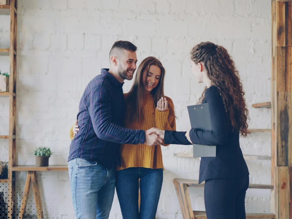 Homebuyers shaking hands with a realtor after a successful home inspection by Buffalo Property Inspections, in a welcoming and professional environment