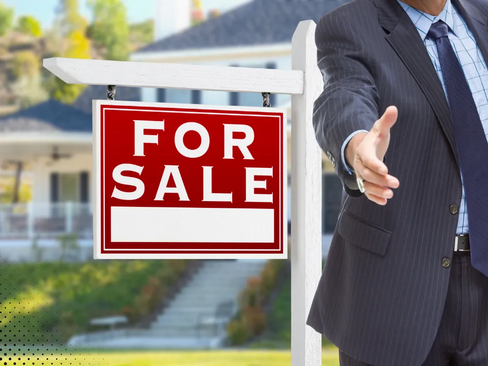 Real estate professional extending a handshake in front of a 'For Sale' sign, symbolizing the sale process facilitated by Buffalo Property Inspections
