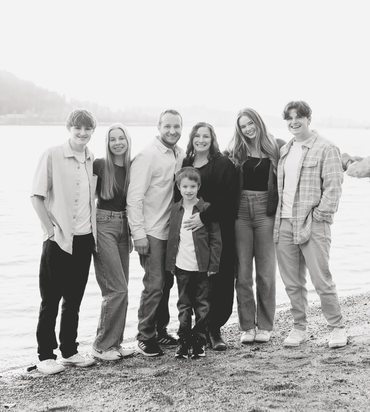 The Candid Apple Collective family standing on the ocean