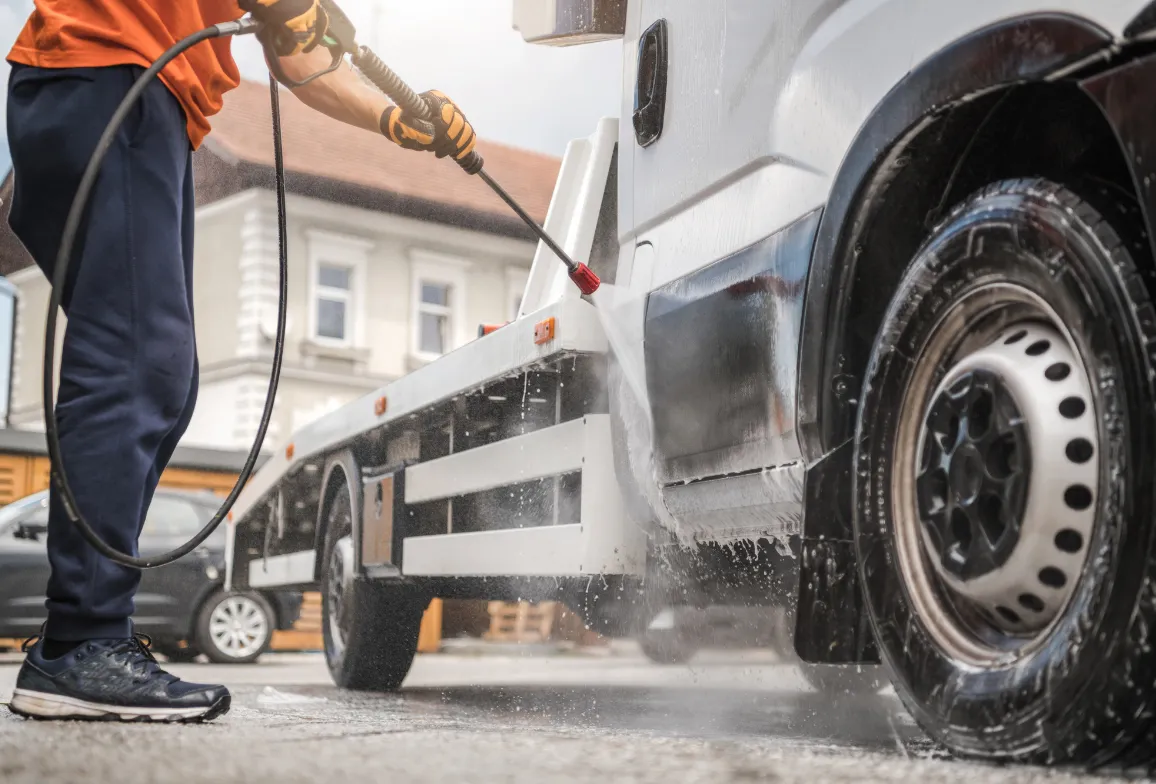 Man pressure washing truck