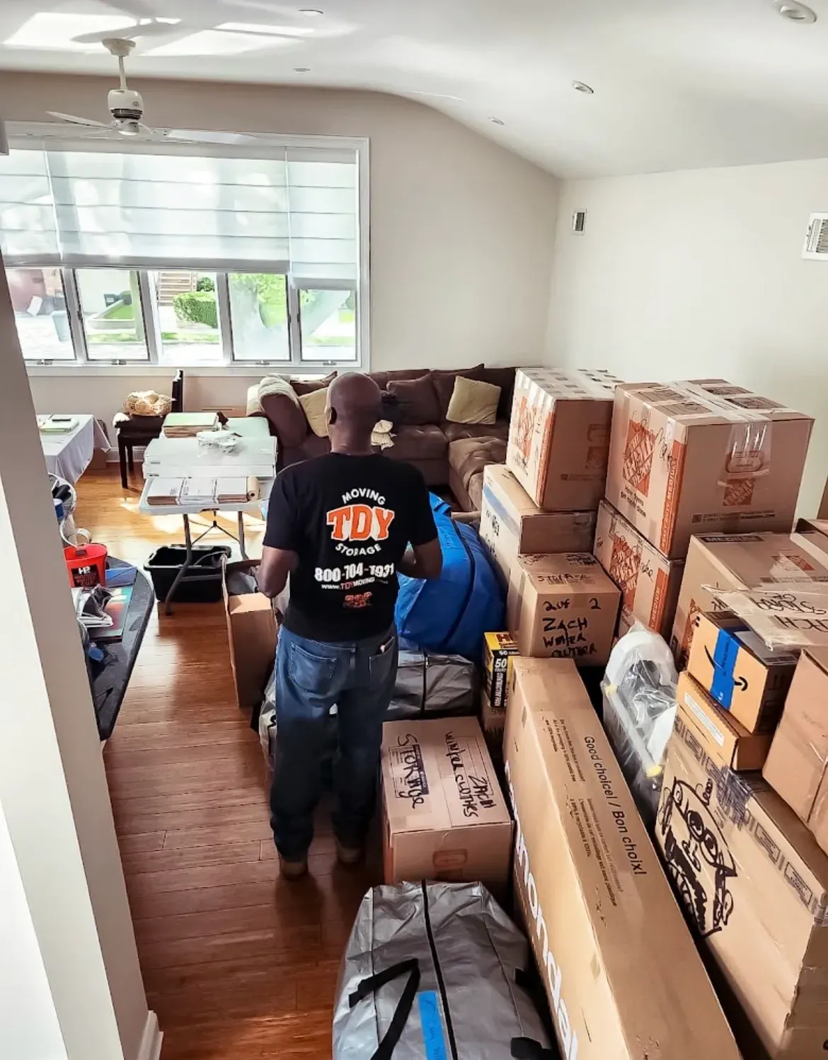 Experienced moving company carrying wrapped furniture inside a home in Brooklyn New York