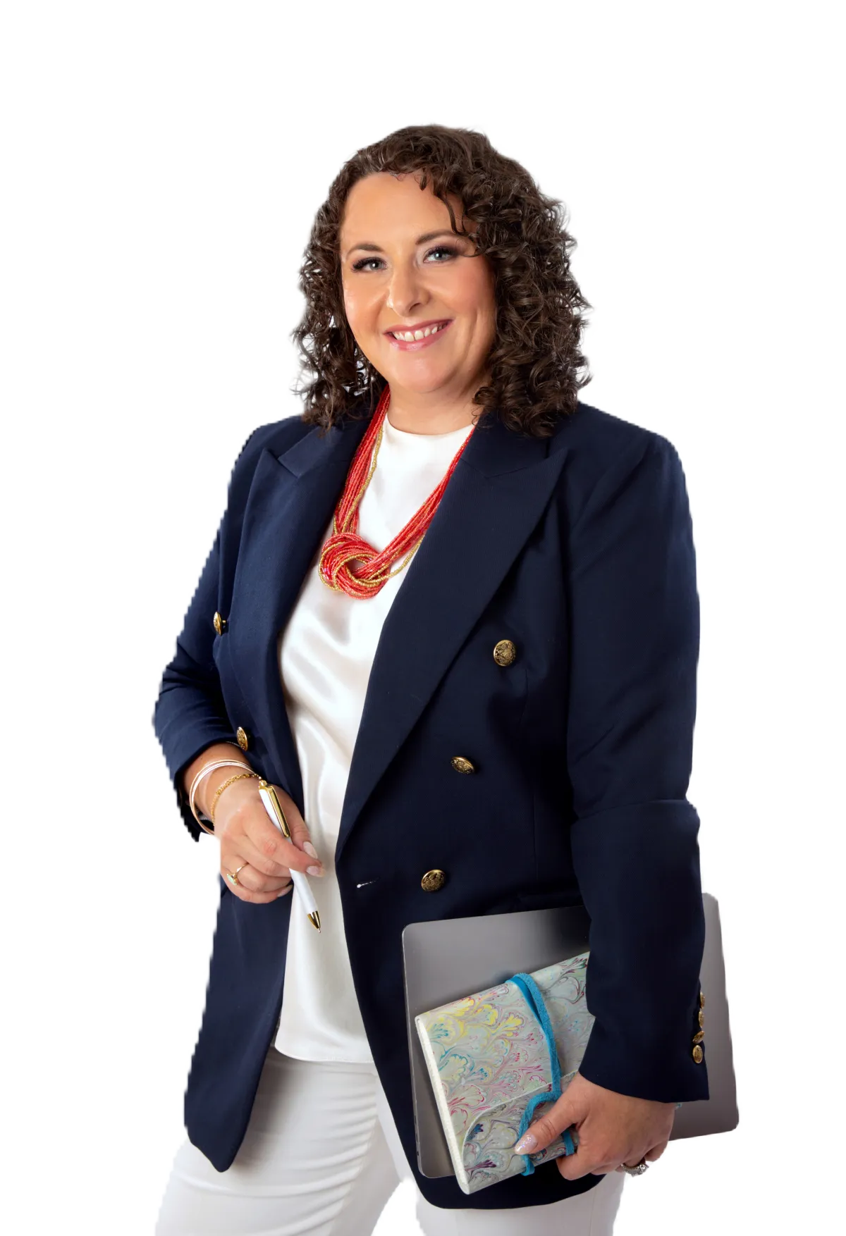 Maria Chapman stands holding a book and smiling at the camera. She's wearing white top and pants and navy blazer.