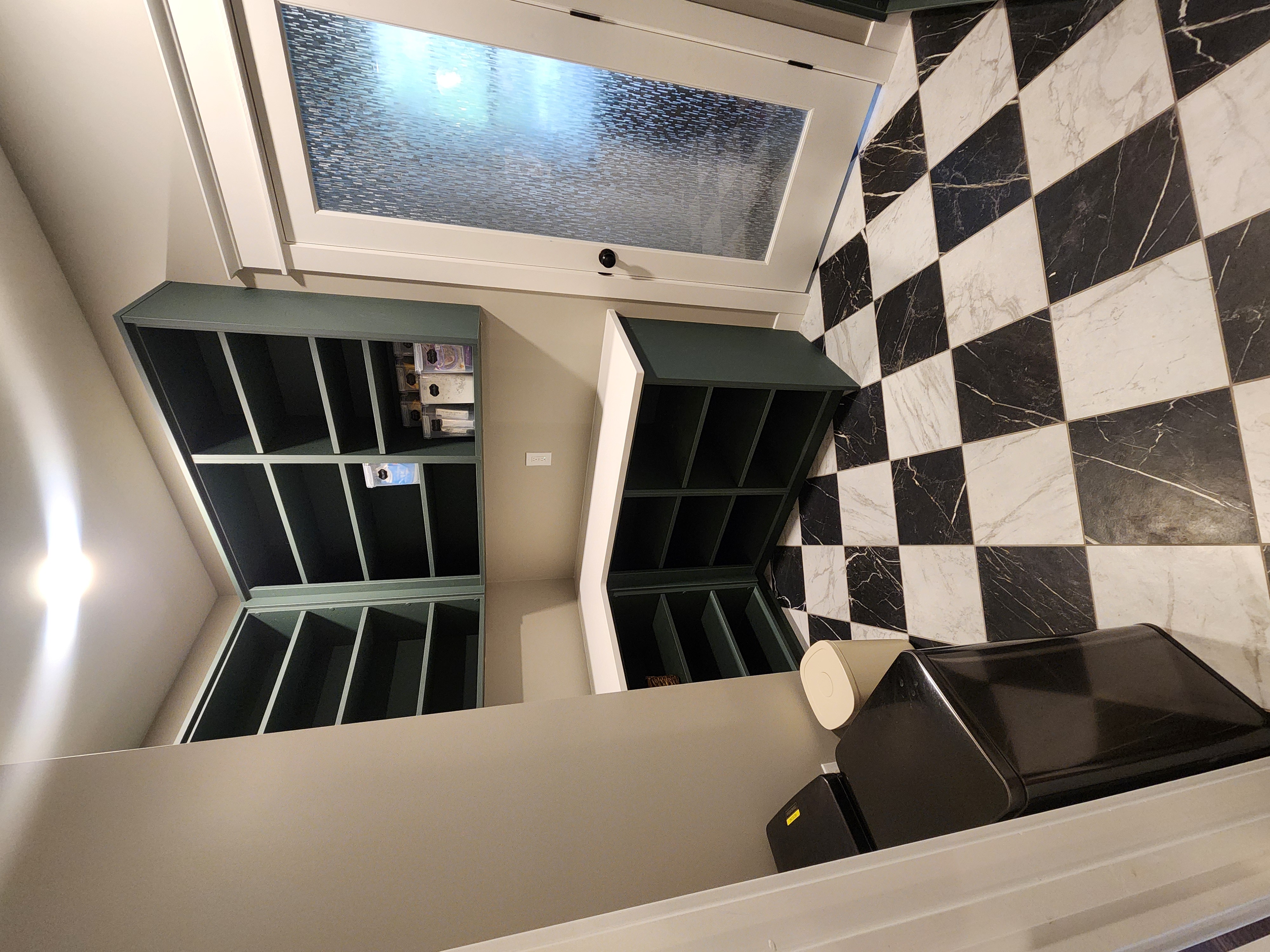 Finished pantry with green shelves, white countertops, and checkerboard tile