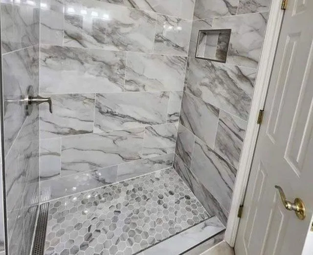 Bathroom shower with marble tile floor and glass door