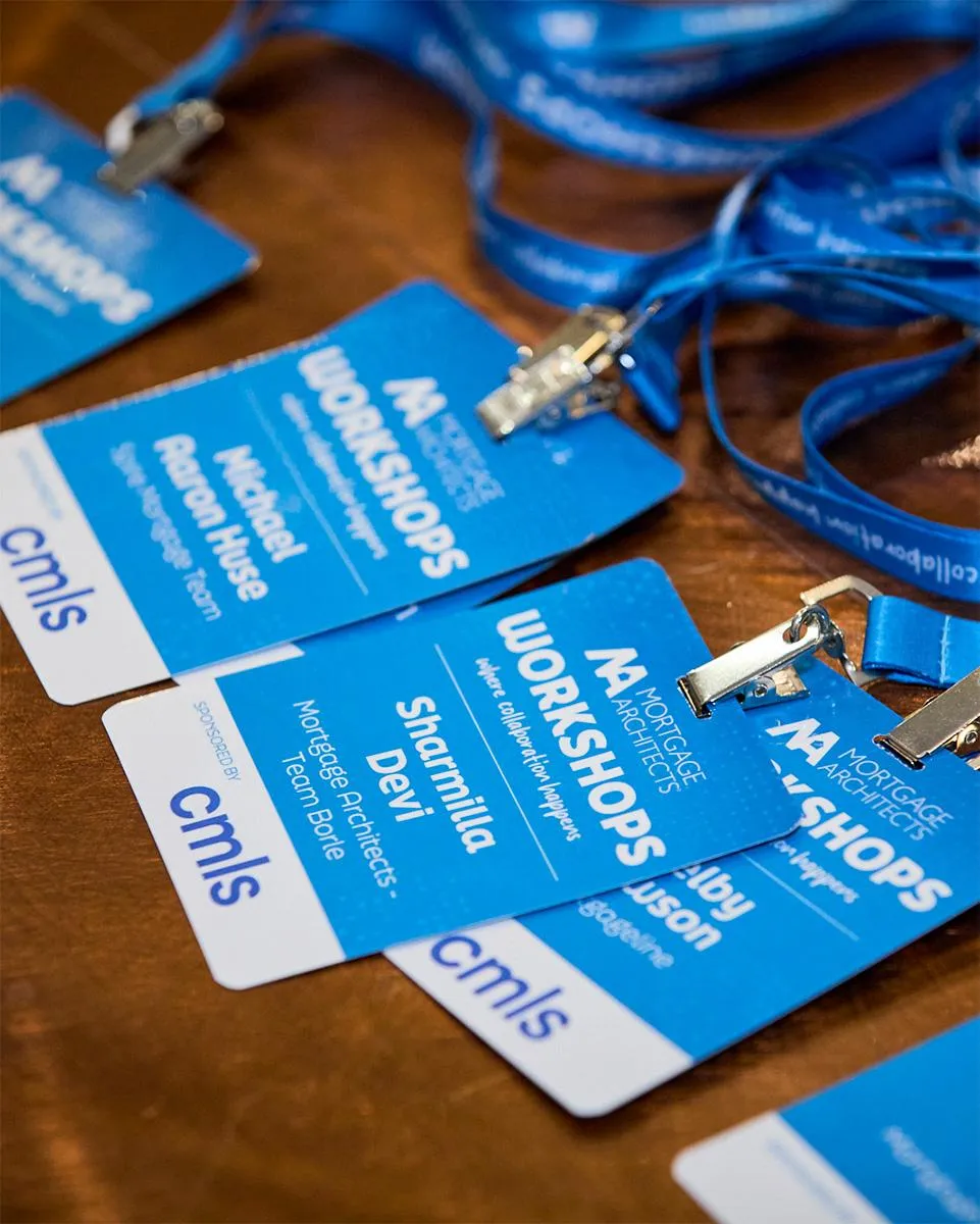 Headshot of a man sitting backwards on a chair and holding his glasses